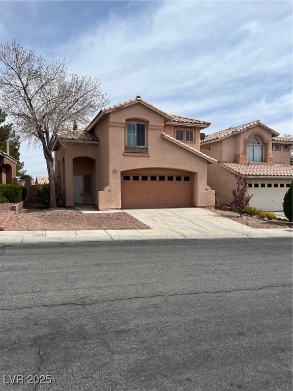 Mediterranean / spanish-style home featuring stucco siding, a garage, concrete driveway, and a tiled roof