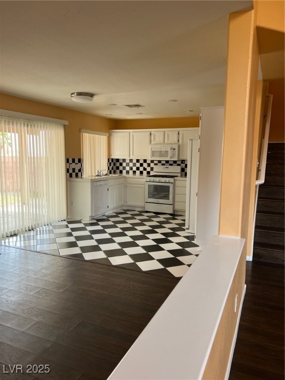 212 Silver Castle Street Las Vegas, NV 89144 - Photo 6 of 24 Kitchen featuring dishwashing machine, stove, white cabinets, dark floors, and tasteful backsplash