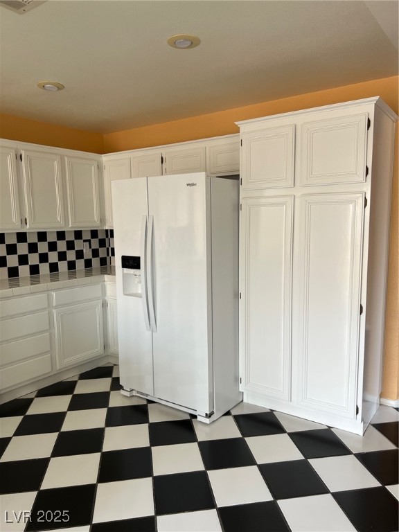 212 Silver Castle Street Las Vegas, NV 89144 - Photo 7 of 24 Kitchen featuring tile patterned floors, white cabinets, white refrigerator with ice dispenser, and tile counters