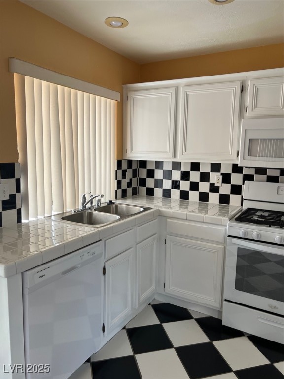 212 Silver Castle Street Las Vegas, NV 89144 - Photo 9 of 24 Kitchen with white cabinetry, a sink, stove, dishwasher, and tile patterned floors