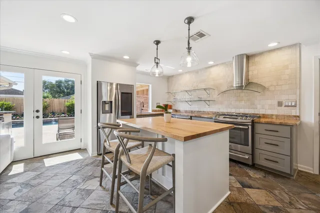 a large white kitchen with a stove a sink a window and a dining table