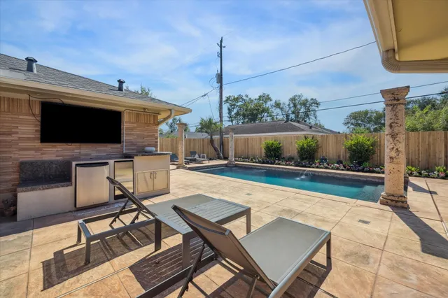 a swimming pool with outdoor seating and plants