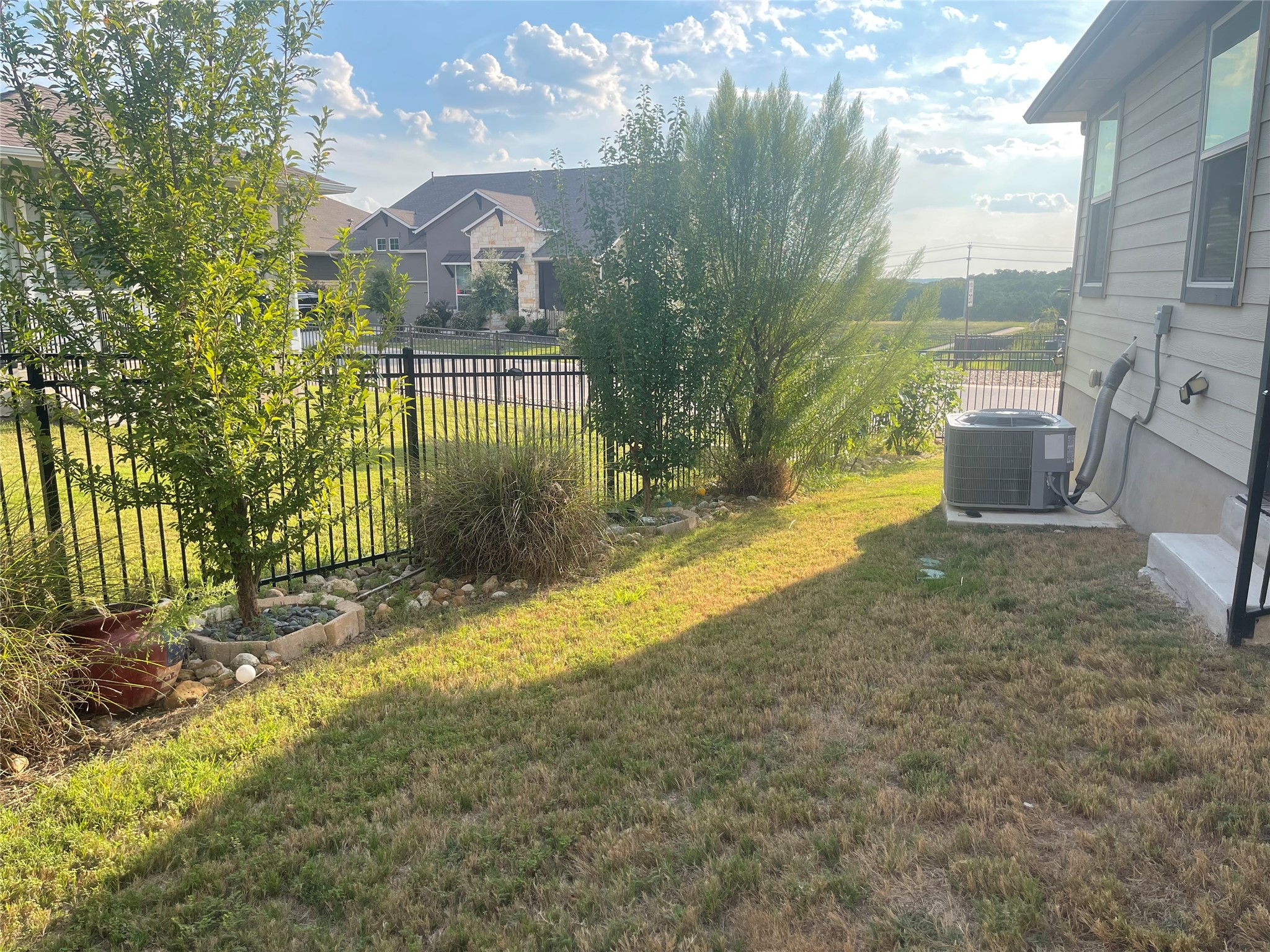 145 Merrick Road Georgetown, TX 78628 - Photo 29 of 32 A fenced grassy yard aligns with the side of the home under sunny skies.