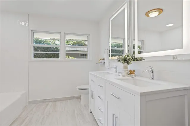 a large white kitchen with a large window