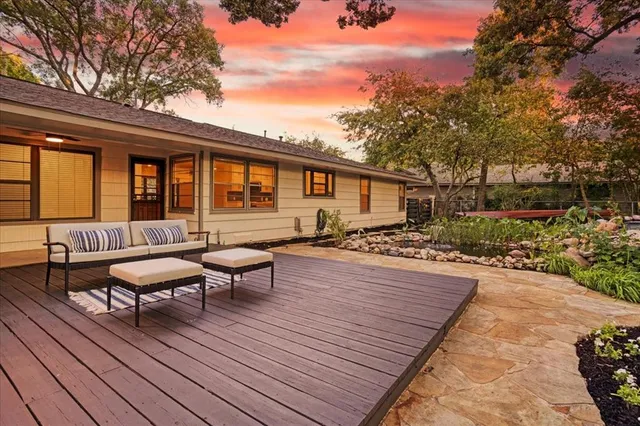 a view of a patio with table and chairs potted plants and large tree