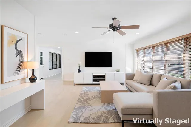 a living room with furniture a flat screen tv and a large window