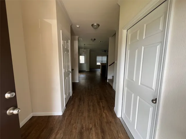 a view of a hallway with wooden floor