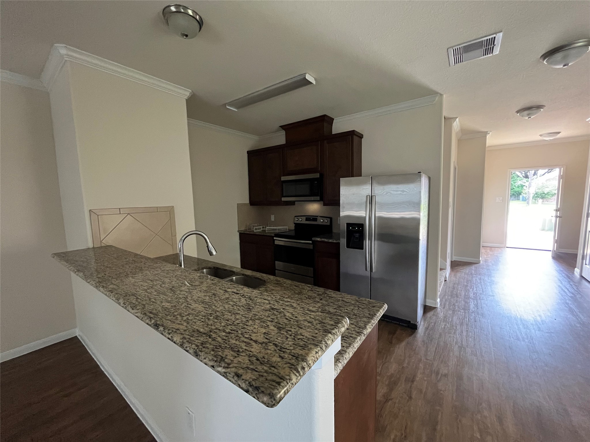 1090 North Colbert Street Dayton, TX 77535 - Photo 4 of 6 a kitchen with kitchen island a counter top space cabinets and stainless steel appliances