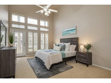 a living room with a bed furniture and a large window