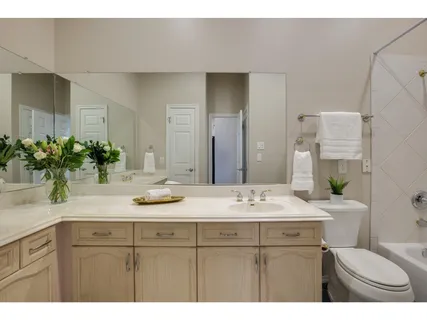 a bathroom with a granite countertop sink a toilet and mirror