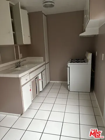 a view of an empty room with wooden floor and windows
