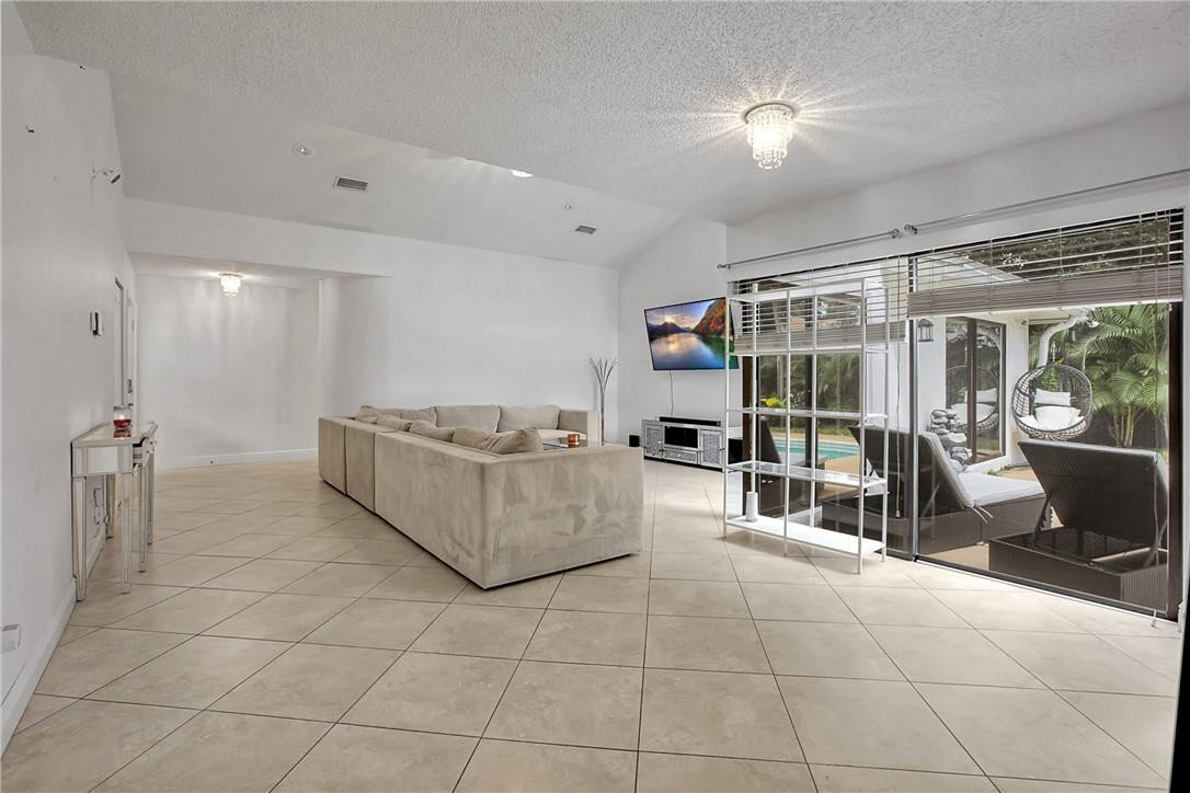 106 Kensington Road Hollywood, FL 33021 - Photo 12 of 42 a living room with furniture a flat screen tv and a glass door