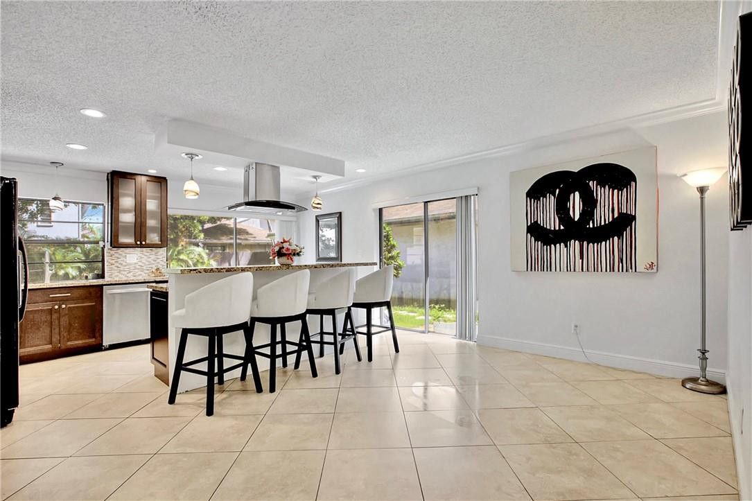 106 Kensington Road Hollywood, FL 33021 - Photo 14 of 42 a kitchen with stainless steel appliances kitchen island granite countertop a sink a stove and cabinets