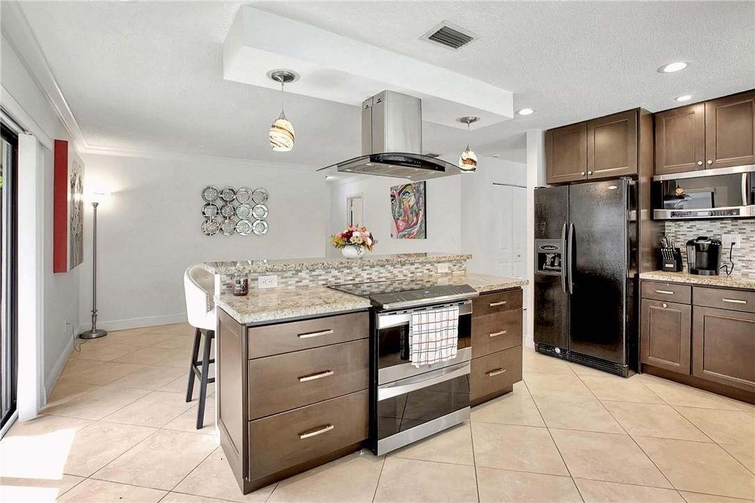 106 Kensington Road Hollywood, FL 33021 - Photo 16 of 42 a kitchen with kitchen island granite countertop cabinets and stainless steel appliances