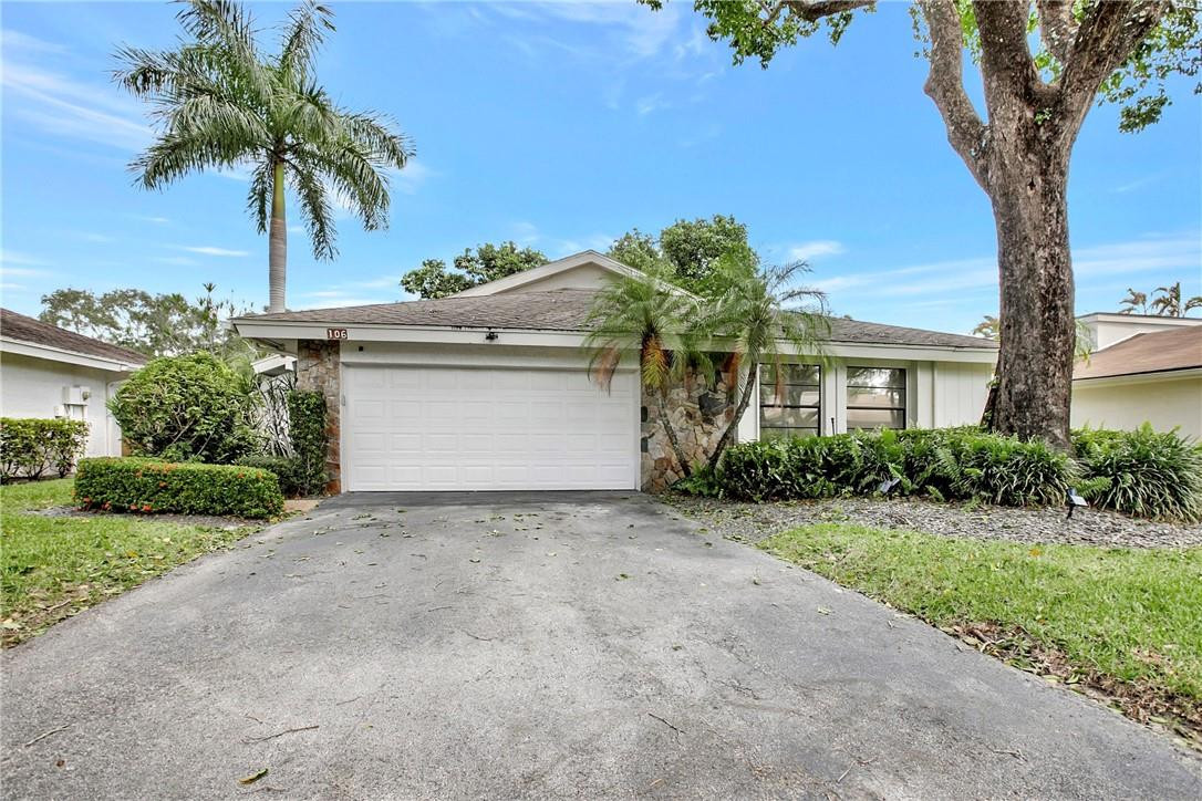 106 Kensington Road Hollywood, FL 33021 - Photo 2 of 42 a front view of a house with a garden and palm trees