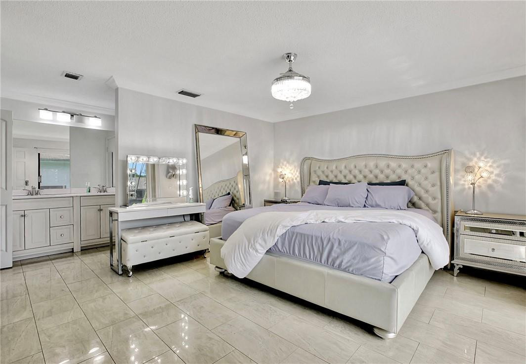 106 Kensington Road Hollywood, FL 33021 - Photo 22 of 42 a spacious bedroom with a bed and ceiling fan