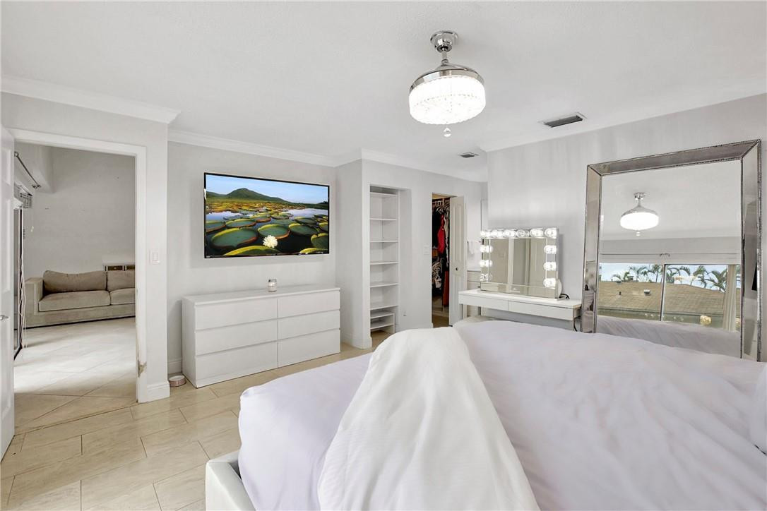 106 Kensington Road Hollywood, FL 33021 - Photo 24 of 42 a spacious bedroom with a bed and a flat screen tv