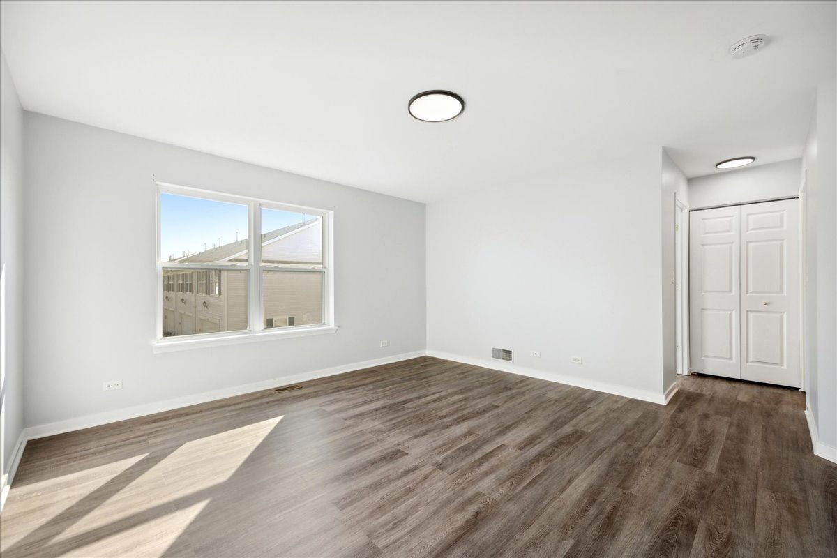 2435 Georgetown Circle Aurora, IL 60503 - Photo 5 of 10 an empty room with wooden floor and windows