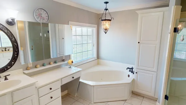 a bathroom with a tub sink and mirror
