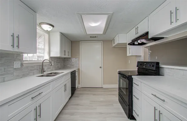 a kitchen with stainless steel appliances a sink dishwasher stove and refrigerator