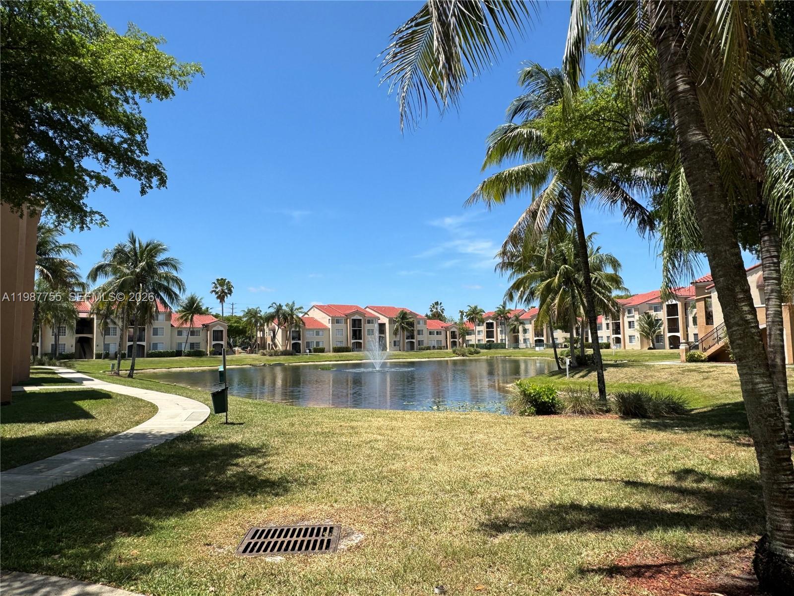 2071 Renaissance Boulevard, Unit 104 Miramar, FL 33025 - Photo 7 of 17 a view of swimming pool with a yard and palm trees