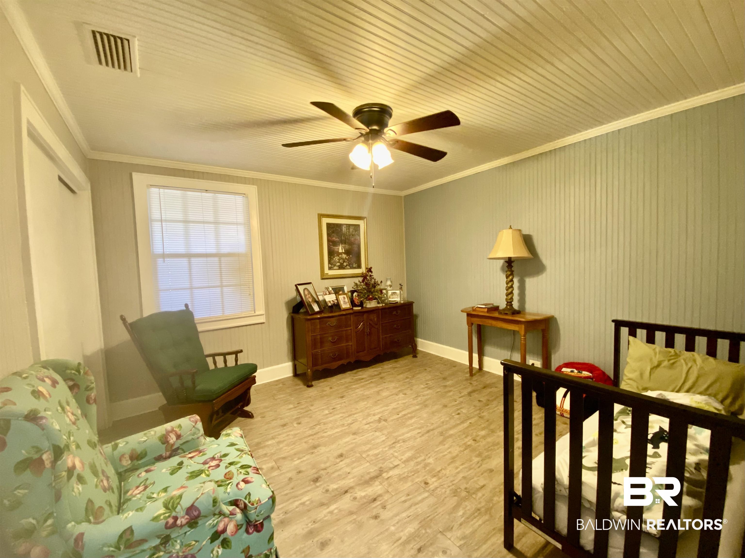 2711 County Road 5 Repton, AL 36475 - Photo 13 of 36 Bedroom featuring ceiling fan, ornamental molding, and light wood-type flooring