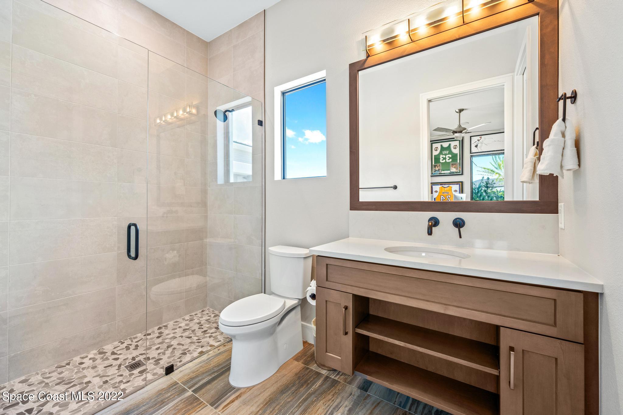 4574 Milost Drive Rockledge, FL 32955 - Photo 28 of 41 a bathroom with a sink toilet a mirror and shower