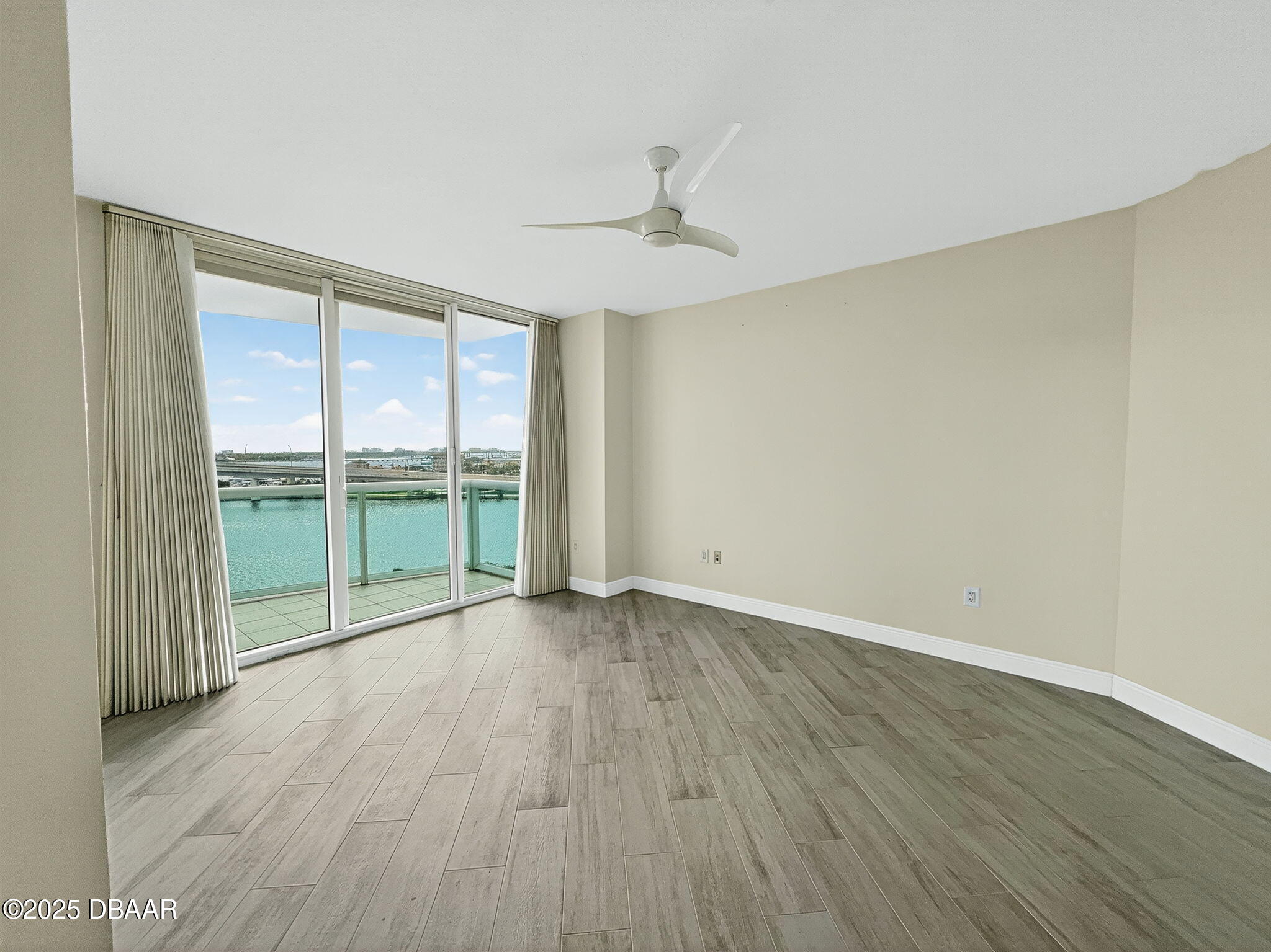 231 Riverside Drive, Unit 903 Holly Hill, FL 32117 - Photo 11 of 28 an empty room with wooden floor and balcony