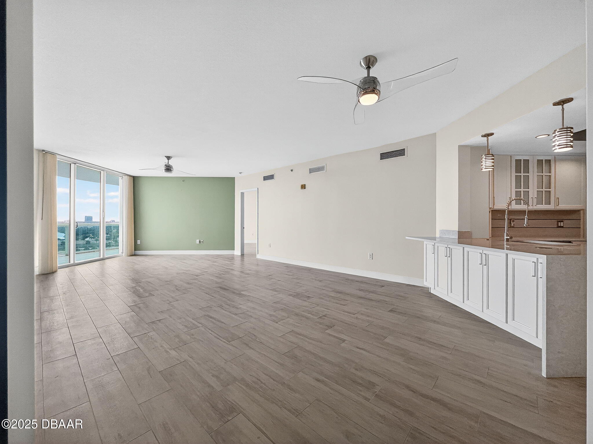 231 Riverside Drive, Unit 903 Holly Hill, FL 32117 - Photo 15 of 28 a view of empty room with wooden floor and fan