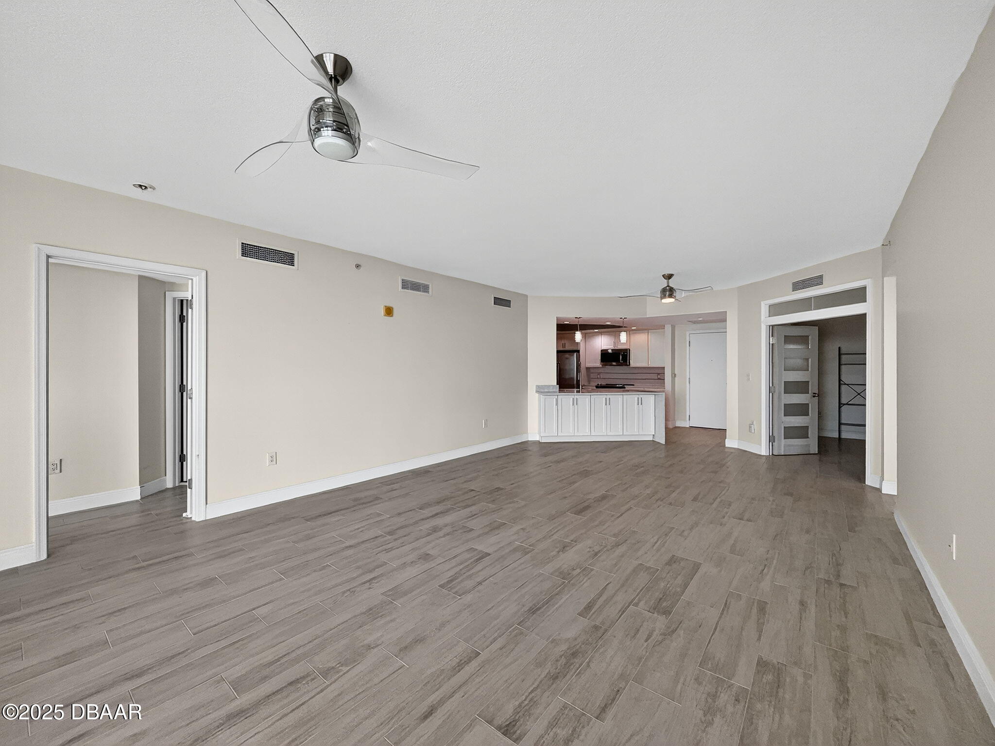 231 Riverside Drive, Unit 903 Holly Hill, FL 32117 - Photo 18 of 28 a view of a room with wooden floor ceiling fan and window