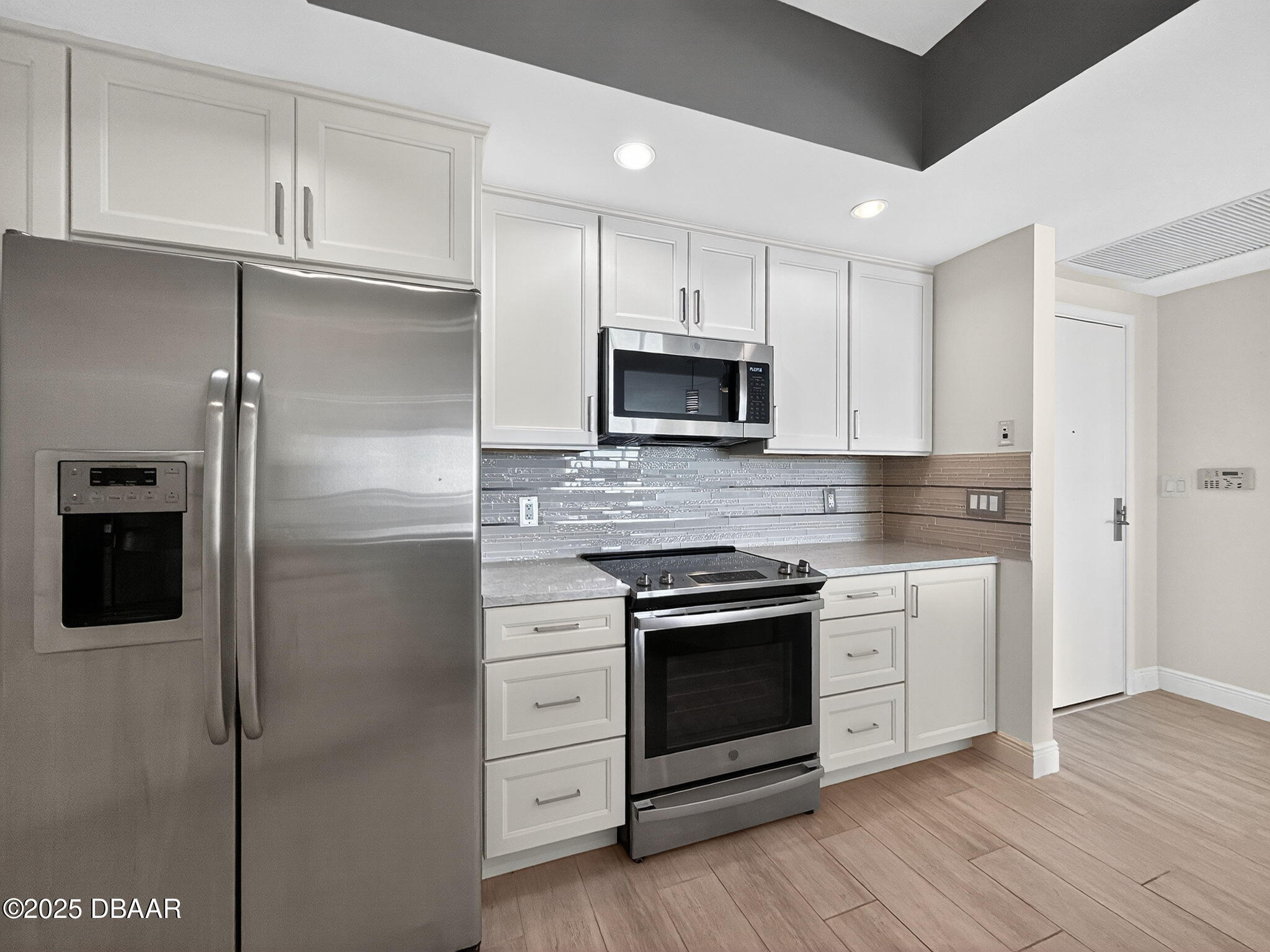 231 Riverside Drive, Unit 903 Holly Hill, FL 32117 - Photo 25 of 28 a kitchen with cabinets stainless steel appliances and wooden floor