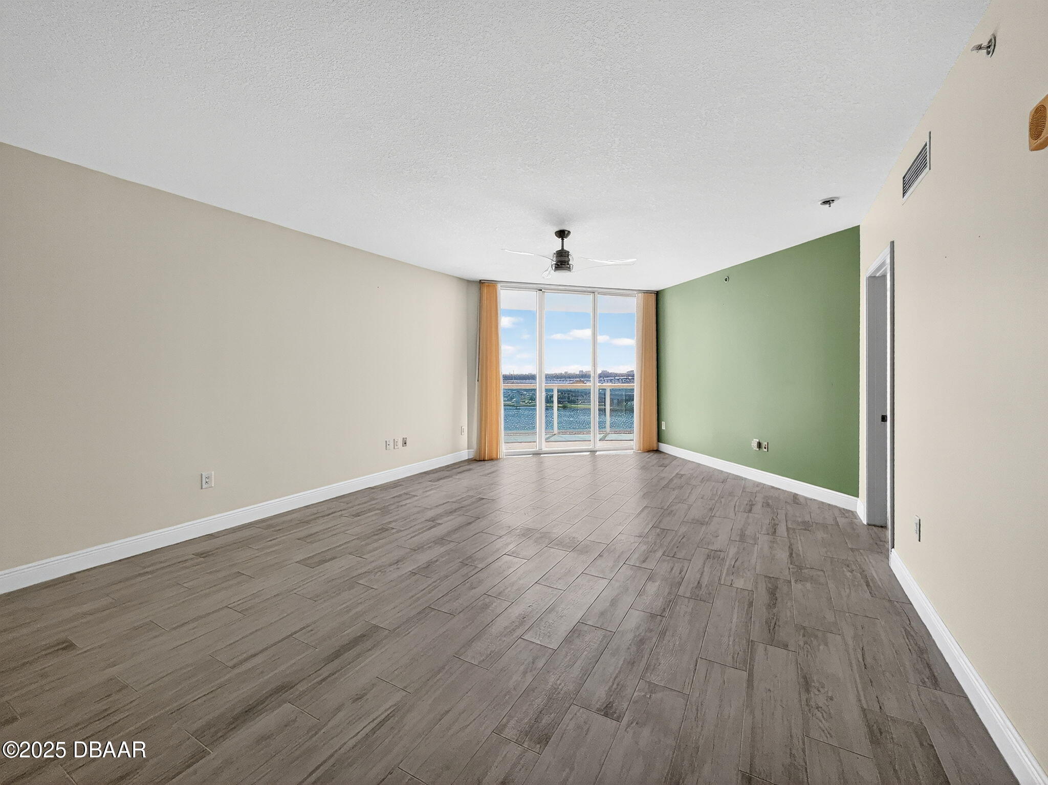 231 Riverside Drive, Unit 903 Holly Hill, FL 32117 - Photo 4 of 28 wooden floor in an empty room with a window