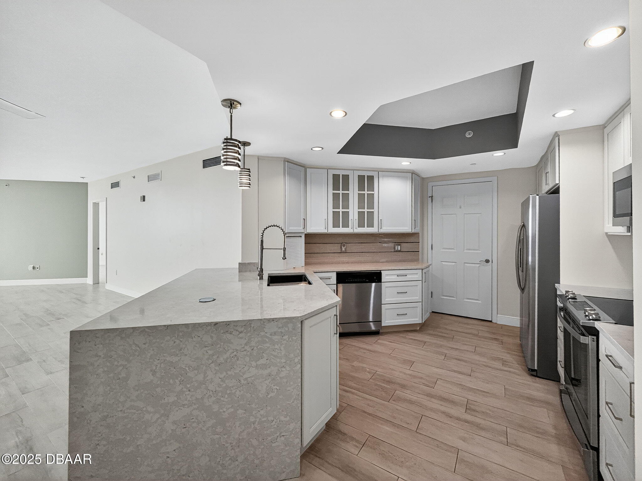 231 Riverside Drive, Unit 903 Holly Hill, FL 32117 - Photo 5 of 28 a kitchen with kitchen island a counter top space a sink stainless steel appliances and cabinets