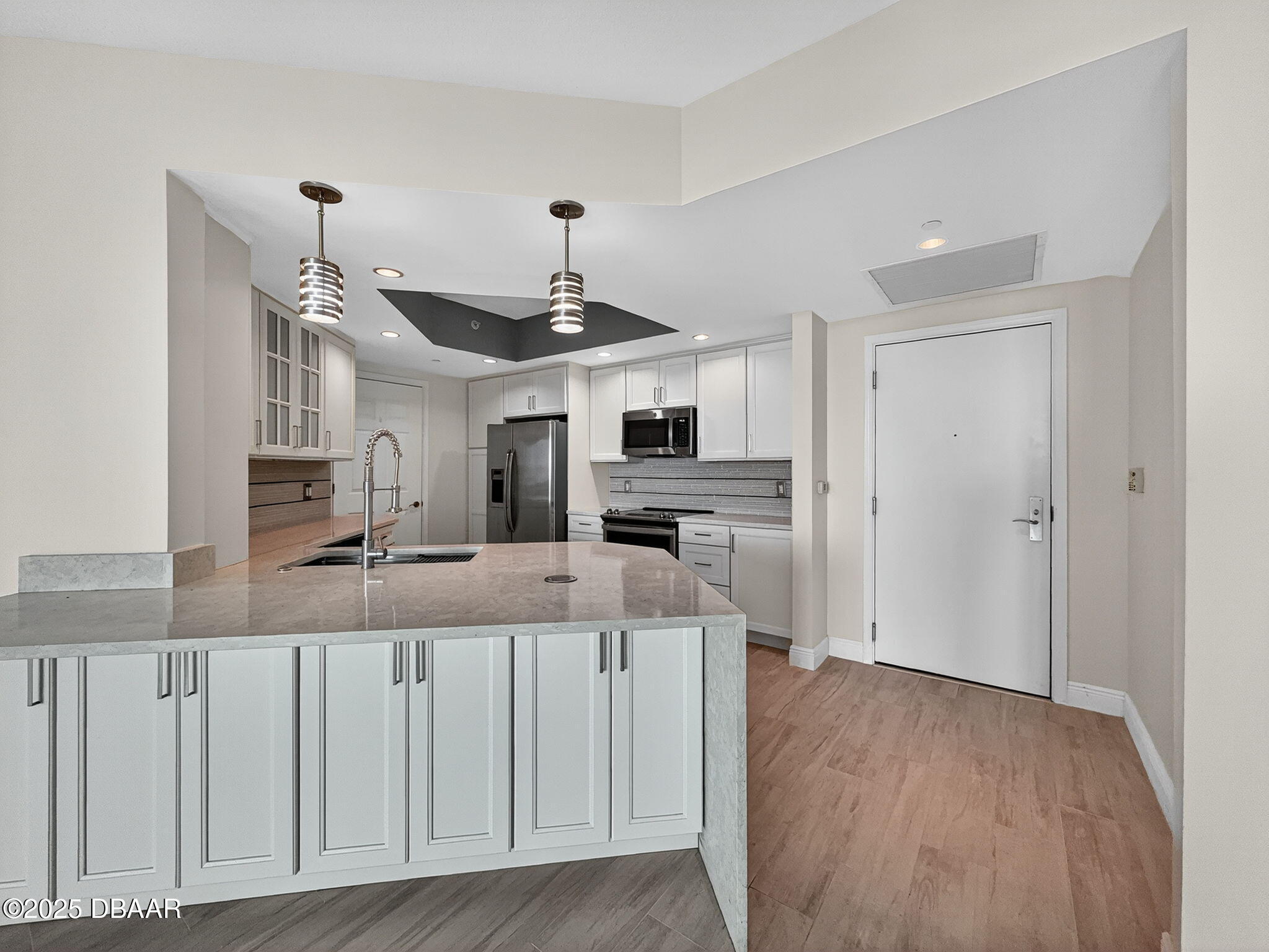 231 Riverside Drive, Unit 903 Holly Hill, FL 32117 - Photo 6 of 28 a view of a kitchen with a sink wooden floor and a living room