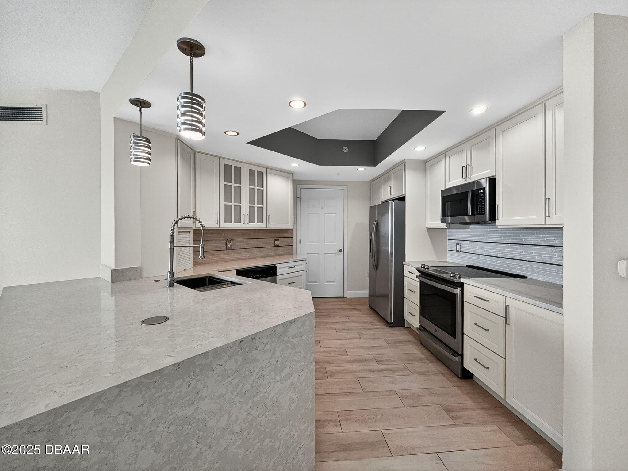 231 Riverside Drive, Unit 903 Holly Hill, FL 32117 - Photo 7 of 28 a kitchen with stainless steel appliances a sink stove and refrigerator
