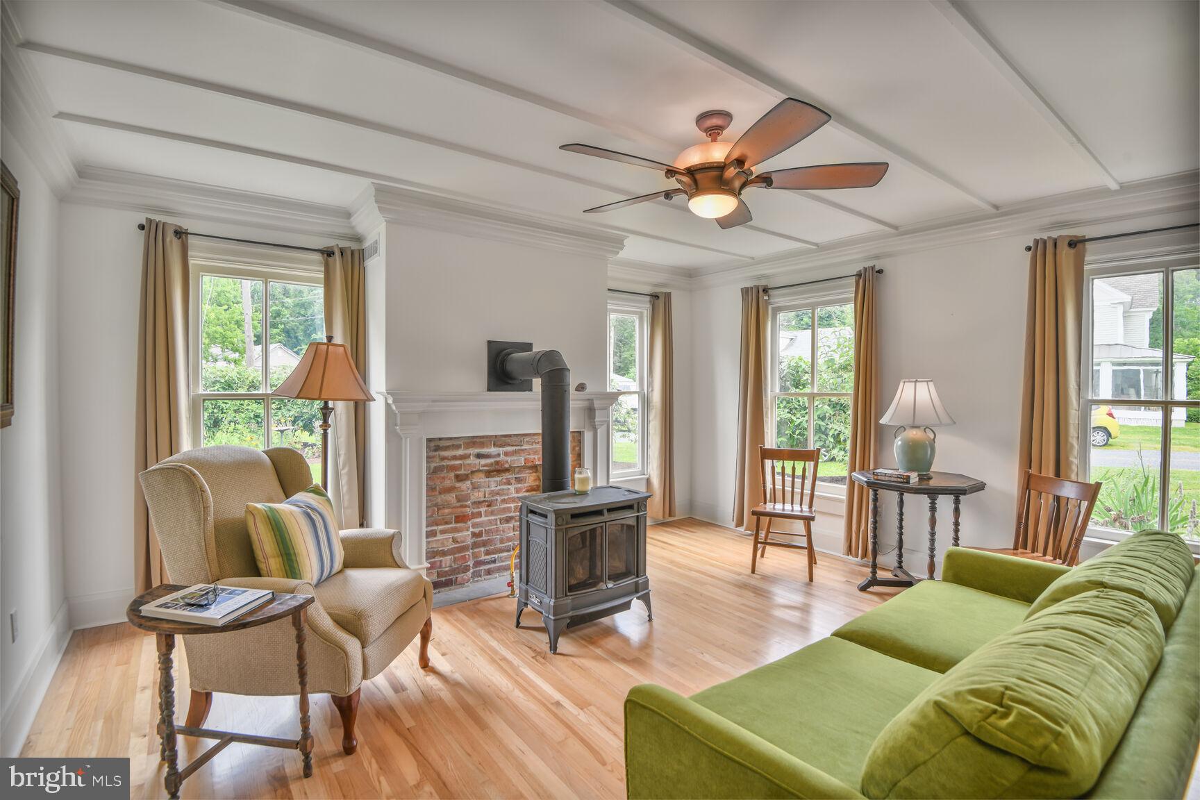 7651 Main Street Tilghman, MD 21671 - Photo 16 of 35 a living room with furniture a ceiling fan a fireplace and a large window