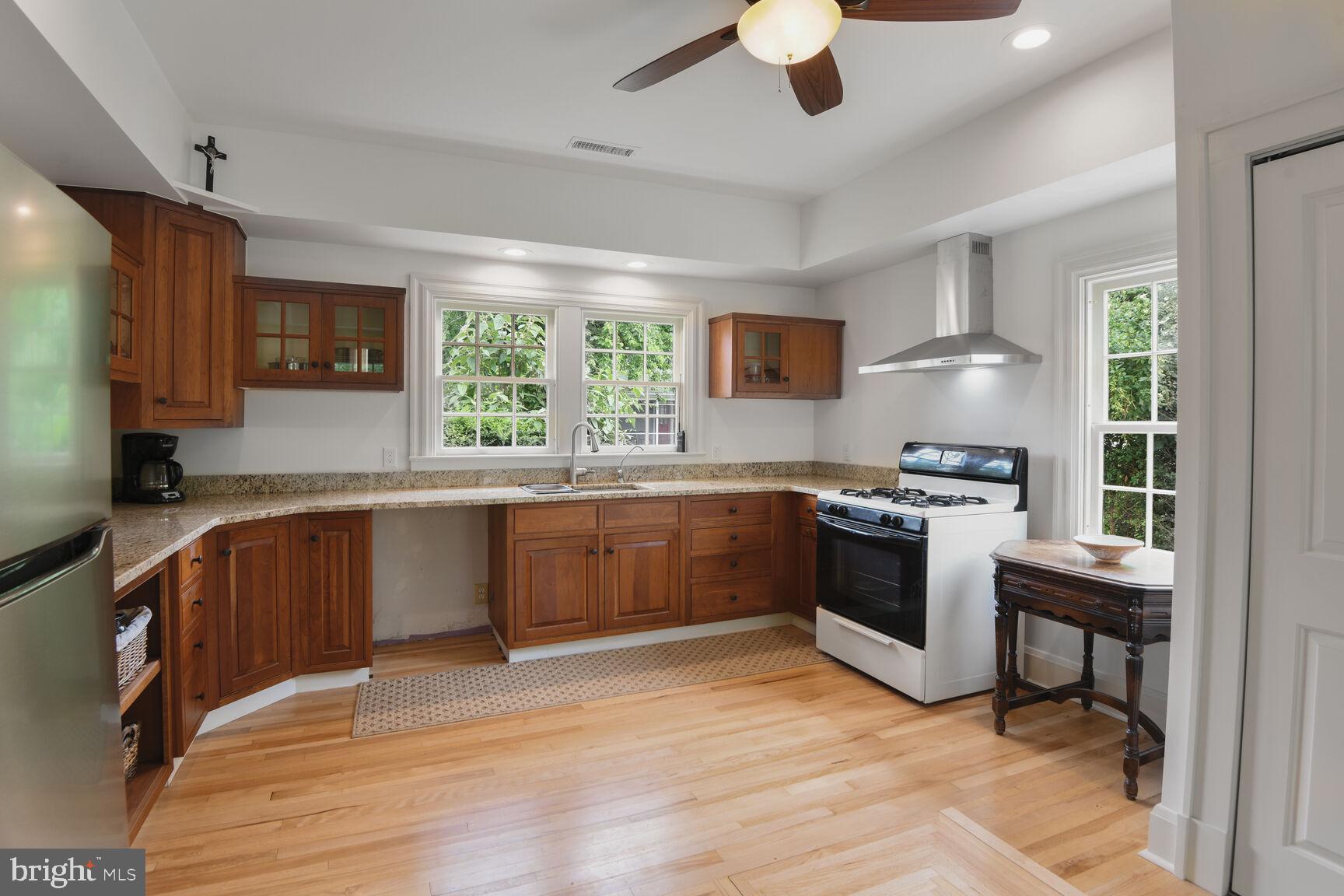 7651 Main Street Tilghman, MD 21671 - Photo 21 of 35 a kitchen with stainless steel appliances kitchen island granite countertop a sink cabinets and wooden floor