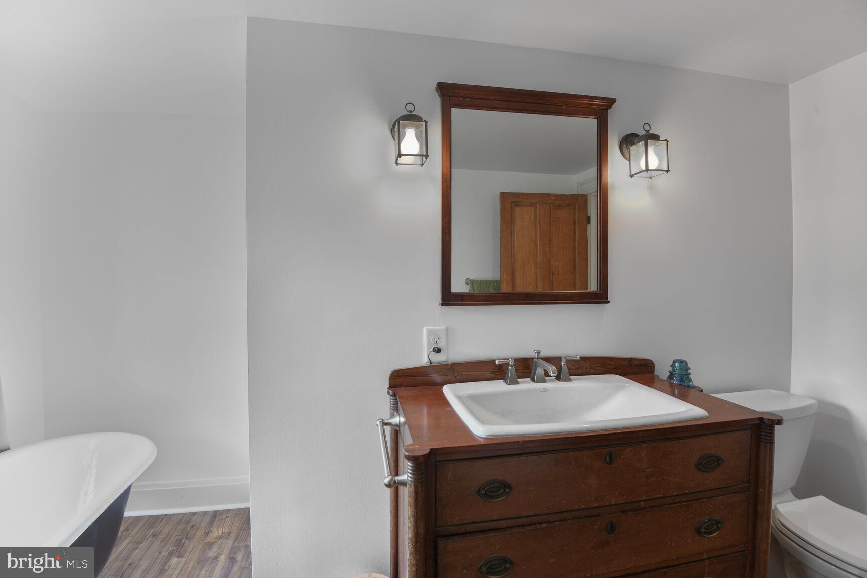 7651 Main Street Tilghman, MD 21671 - Photo 29 of 35 a bathroom with a toilet sink and mirror