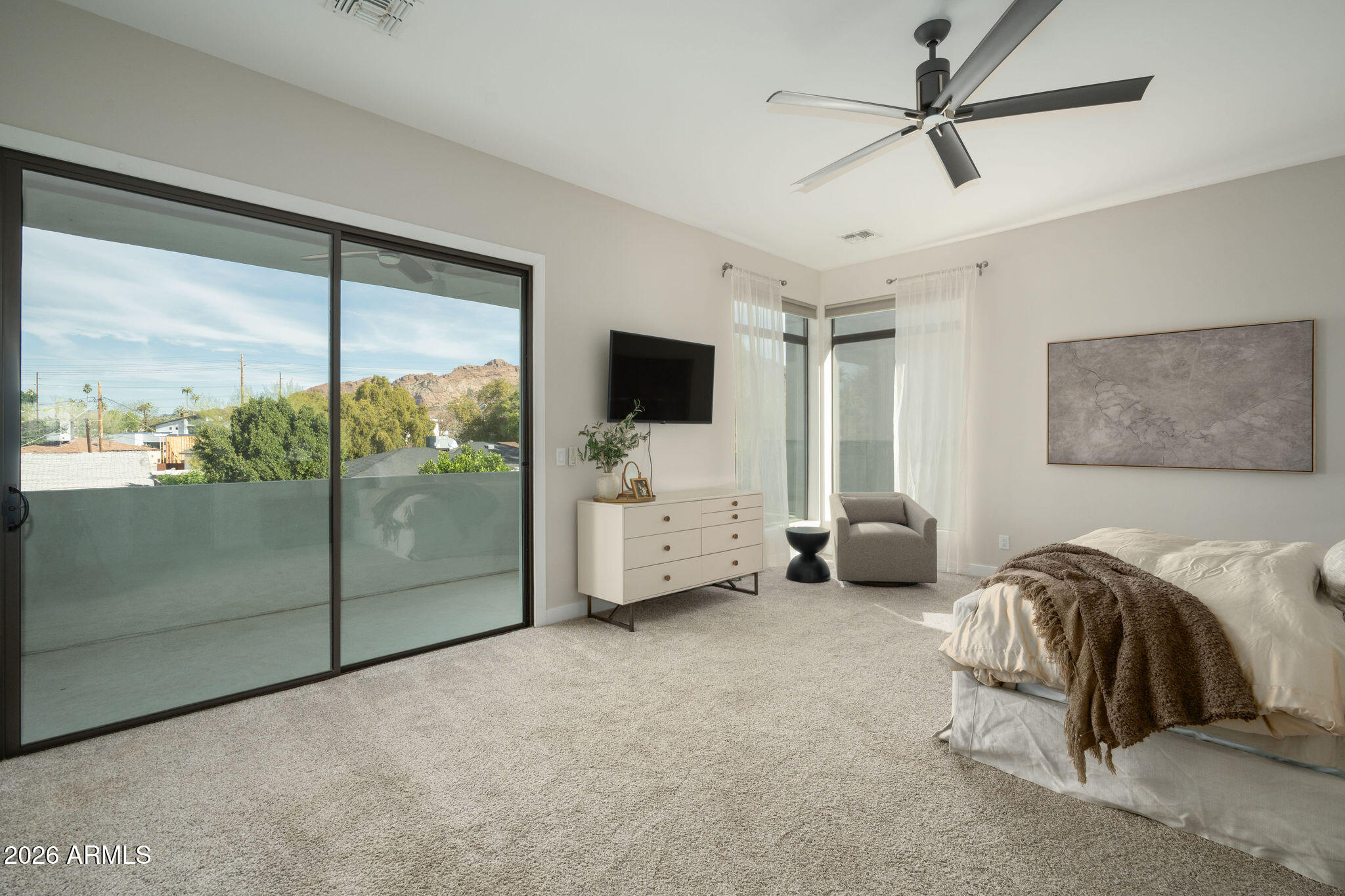 4533 East Montecito Avenue Phoenix, AZ 85018 - Photo 15 of 29 a spacious bedroom with a bed a flat screen tv and a large window