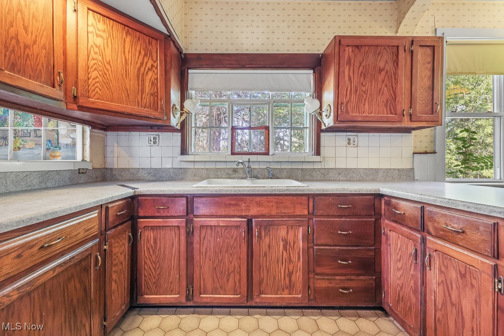 6727 Waterloo Road Atwater, OH 44201 - Photo 20 of 48 Kitchen featuring light countertops, tasteful backsplash, and brown cabinets