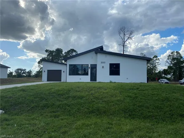 a front view of house with yard and trees
