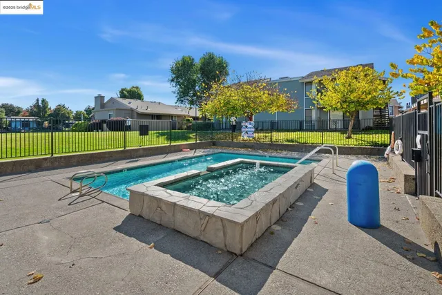a view of a backyard with swimming pool and seating