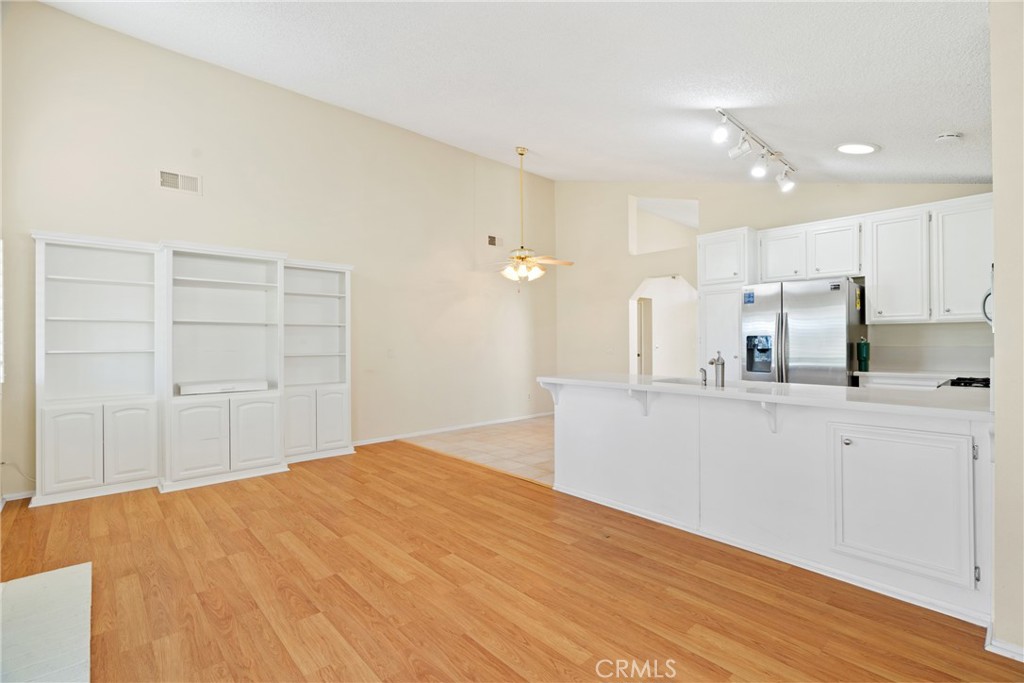 5772 Riviera Avenue Banning, CA 92220 - Photo 15 of 60 a large white kitchen with kitchen island a sink a center island stainless steel appliances and a cabinets