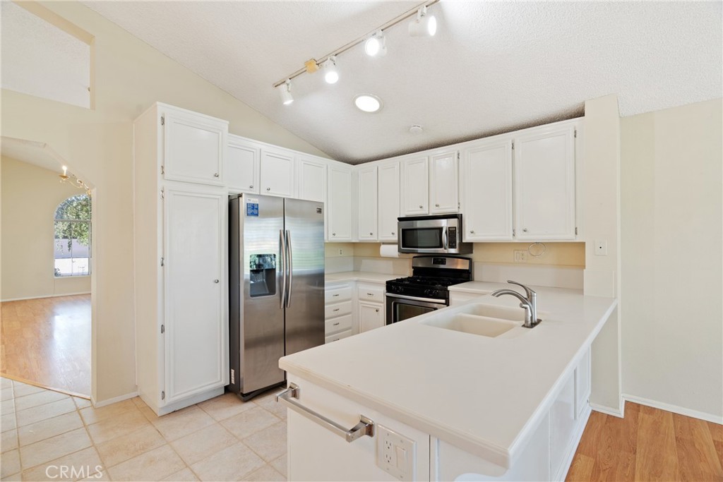 5772 Riviera Avenue Banning, CA 92220 - Photo 19 of 60 a kitchen with white cabinets and stainless steel appliances