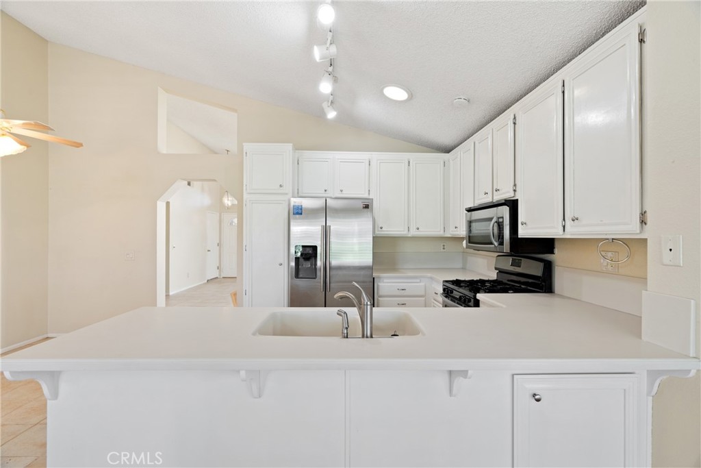 5772 Riviera Avenue Banning, CA 92220 - Photo 21 of 60 a kitchen with stainless steel appliances a refrigerator sink and white cabinets