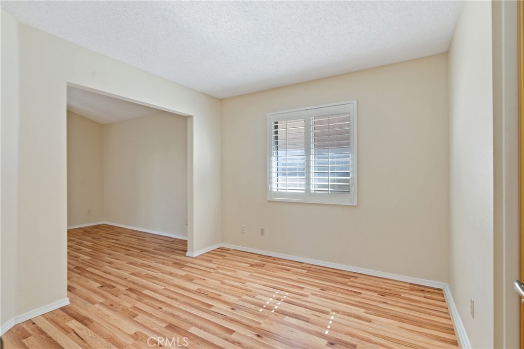 5772 Riviera Avenue Banning, CA 92220 - Photo 23 of 60 a view of an empty room with wooden floor and a window