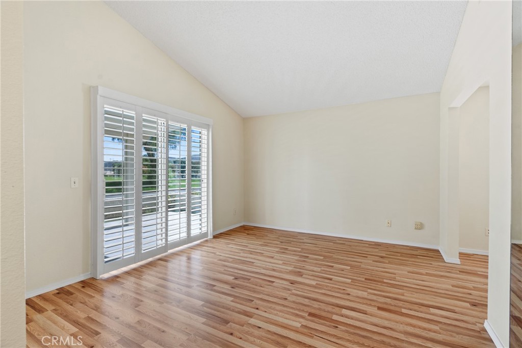 5772 Riviera Avenue Banning, CA 92220 - Photo 31 of 60 a view of an empty room with wooden floor and a window