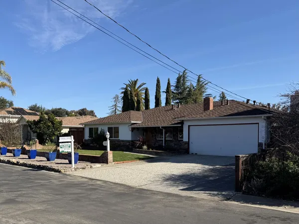 a front view of a house with a garden and parking