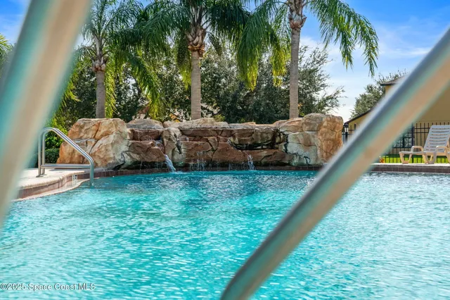 a view of a swimming pool with outdoor seating and plants