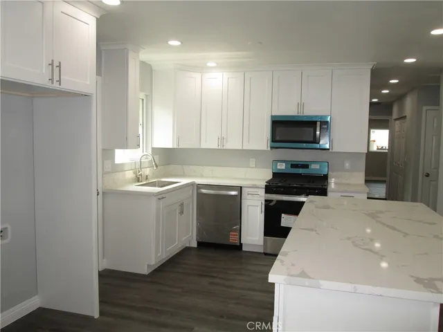 a kitchen with a sink a stove and cabinets